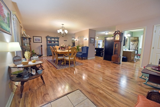 living room with a notable chandelier, a textured ceiling, and wood-type flooring