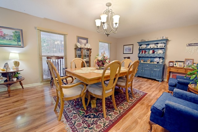 dining space featuring an inviting chandelier and light wood-type flooring