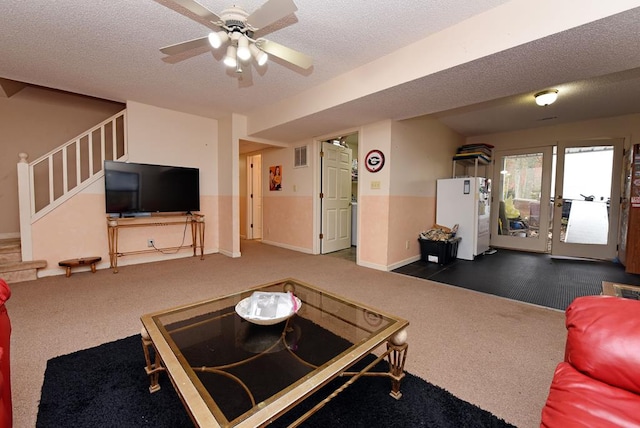 living room featuring dark carpet, a textured ceiling, and ceiling fan