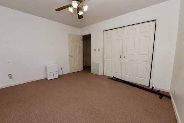 unfurnished bedroom featuring a closet, a textured ceiling, carpet, and ceiling fan