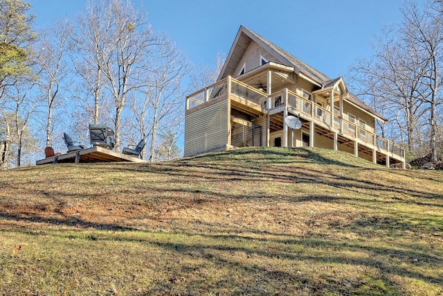 rear view of property with a deck and a yard