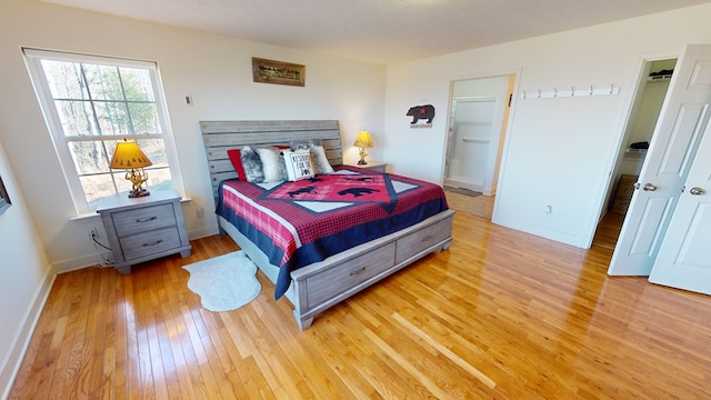 bedroom featuring a spacious closet and light hardwood / wood-style floors