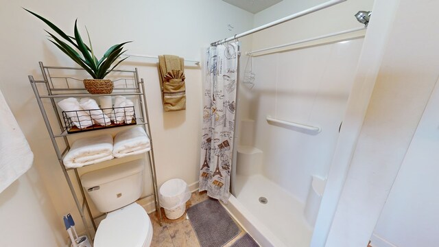 bathroom featuring walk in shower and toilet