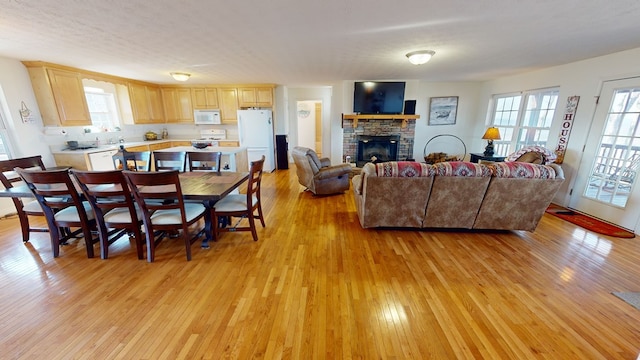 living room with light hardwood / wood-style floors and a brick fireplace