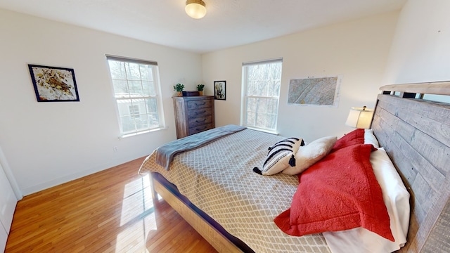 bedroom with light hardwood / wood-style floors and multiple windows