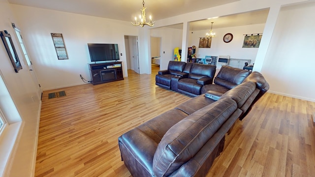 living room featuring a notable chandelier and light hardwood / wood-style floors