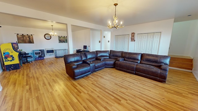 living room with a chandelier and light hardwood / wood-style flooring