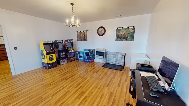 home office with a notable chandelier and light hardwood / wood-style flooring