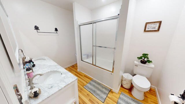 bathroom featuring dual vanity, toilet, and hardwood / wood-style flooring