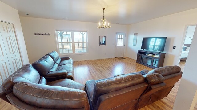 living room featuring an inviting chandelier and light wood-type flooring