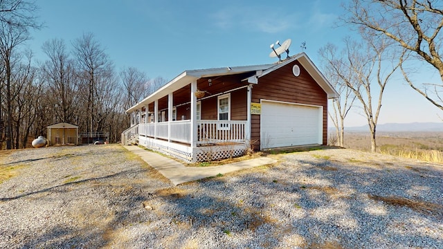 exterior space featuring a porch, an outdoor structure, and a garage