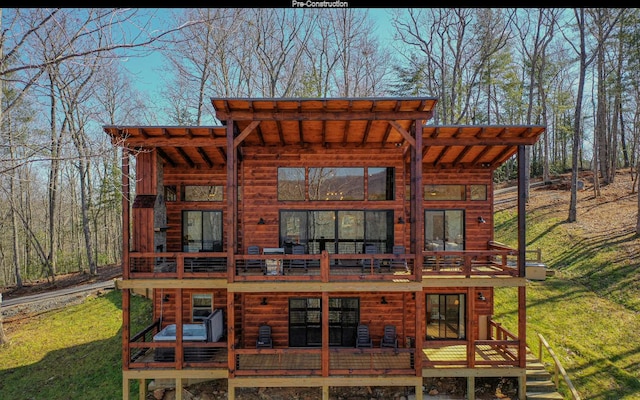 back of house featuring a deck, a pergola, and a yard