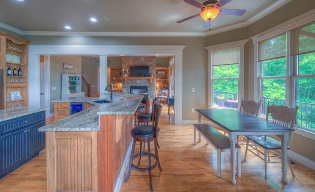 41 Elm Ct, Murphy, NC 28906 - kitchen featuring wine cooler, ornamental molding, a ceiling fan, light wood finished floors, and a stone fireplace