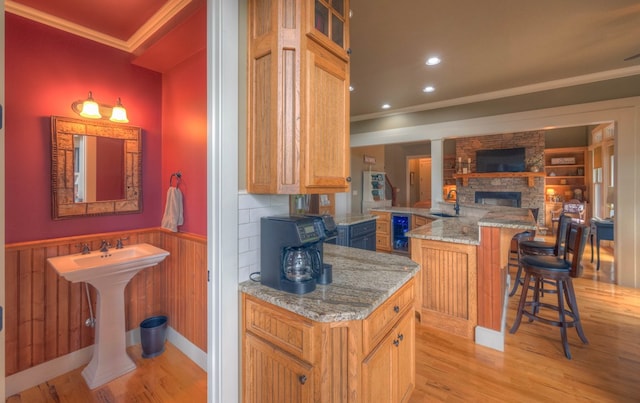 41 Elm Ct, Murphy, NC 28906 - kitchen featuring crown molding, wainscoting, light wood-style flooring, a breakfast bar, and light stone counters