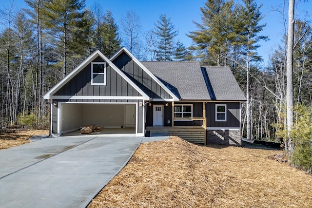 view of front facade featuring board and batten siding, concrete driveway, an attached garage, and a shingled roof