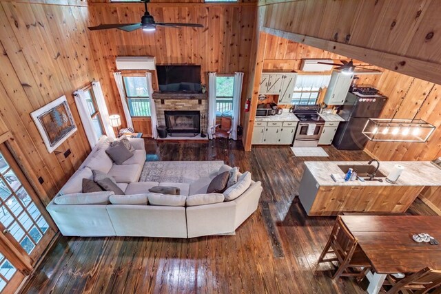 318 Buck Ridge Rd, Suches, GA 30572 - living area with dark wood finished floors, wooden walls, a ceiling fan, and high vaulted ceiling