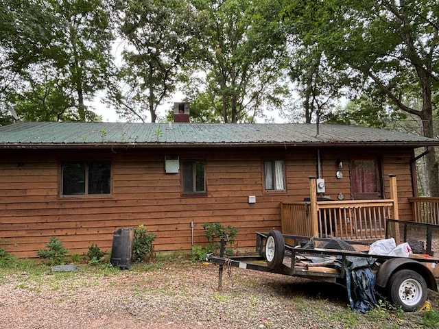 rear view of property featuring a wooden deck