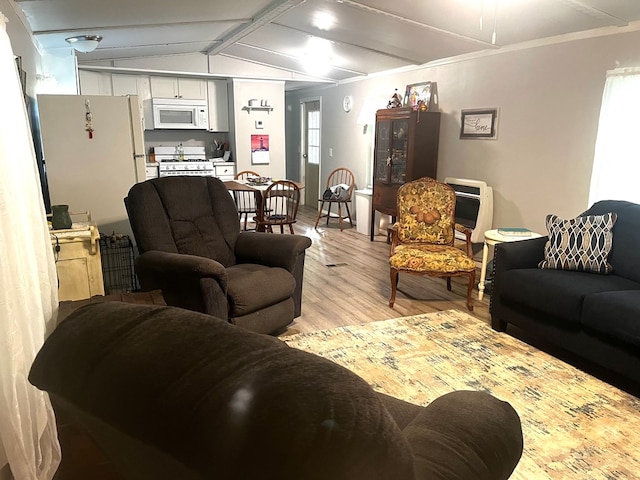 living room featuring vaulted ceiling with beams, heating unit, and light hardwood / wood-style floors