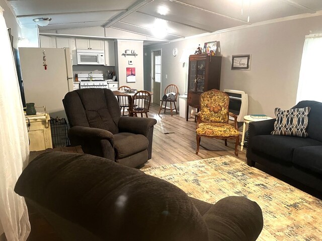 living room with ceiling fan, wood-type flooring, and vaulted ceiling