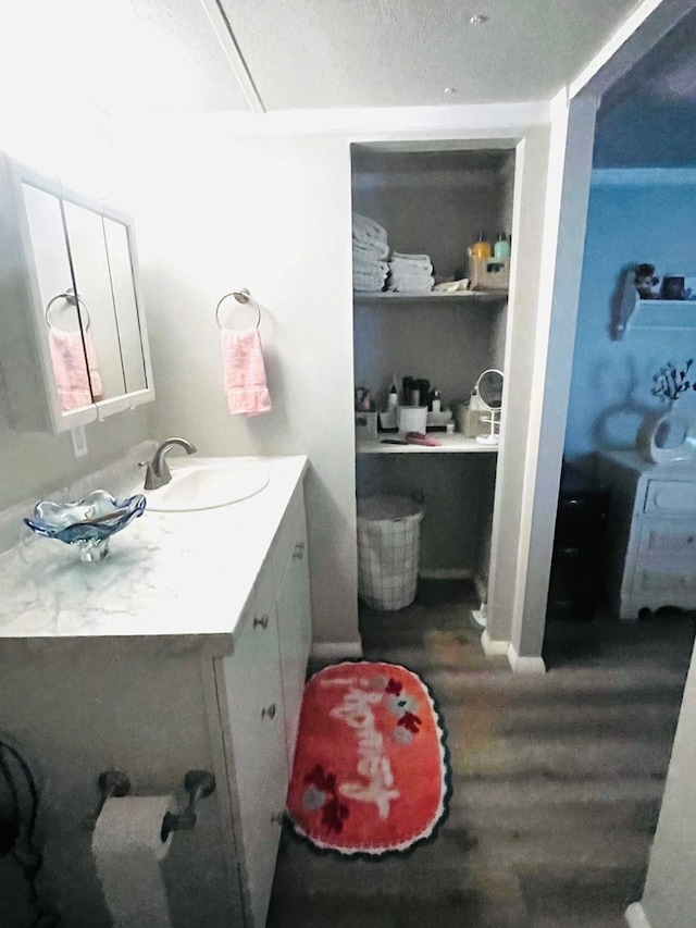 bathroom featuring hardwood / wood-style flooring, a textured ceiling, and vanity