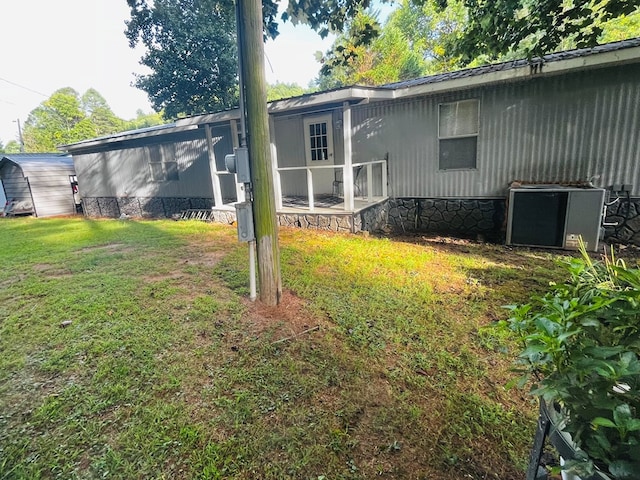 rear view of house with central AC unit and a yard