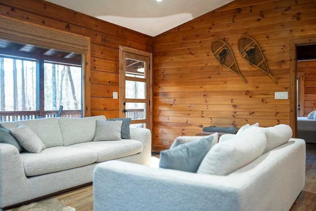 living room with wooden walls, lofted ceiling, and wood-type flooring