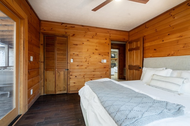 bedroom featuring wood walls, ceiling fan, a closet, and dark hardwood / wood-style flooring