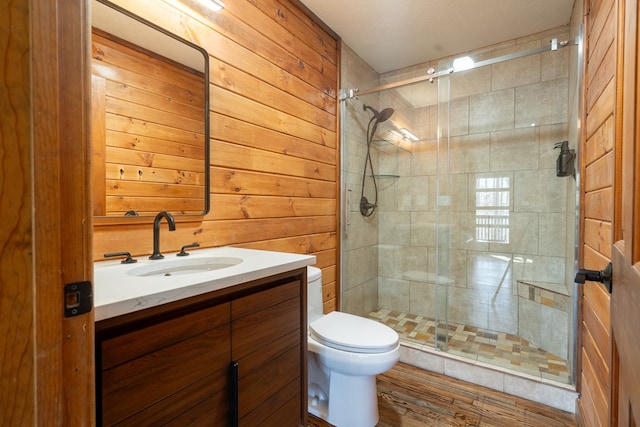 bathroom featuring vanity, wood walls, an enclosed shower, hardwood / wood-style flooring, and toilet