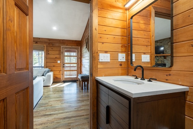 bathroom with vanity, wooden walls, and hardwood / wood-style floors