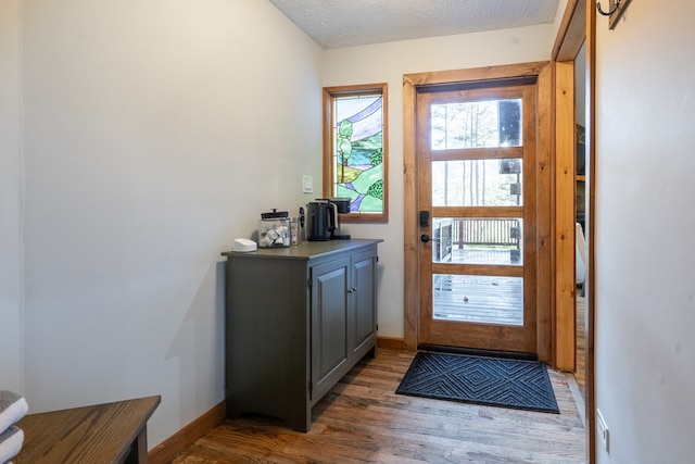 doorway to outside with dark hardwood / wood-style floors and a textured ceiling