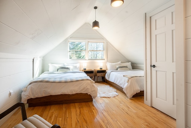 bedroom with vaulted ceiling and wood-type flooring