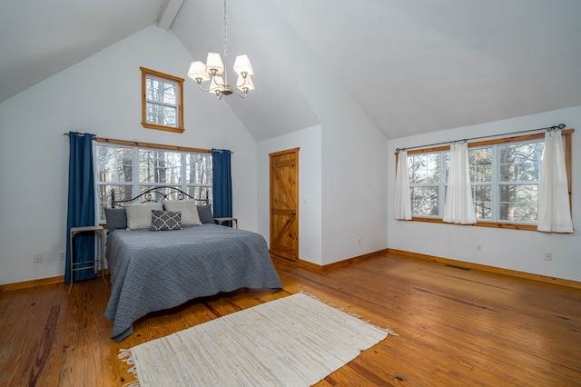 bedroom with beam ceiling, wood-type flooring, a chandelier, and high vaulted ceiling