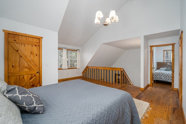 bedroom with vaulted ceiling, a chandelier, and hardwood / wood-style floors