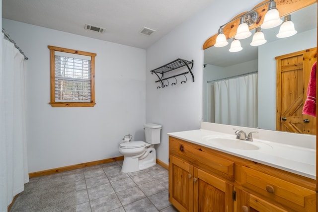 bathroom featuring tile patterned flooring, vanity, a textured ceiling, and toilet