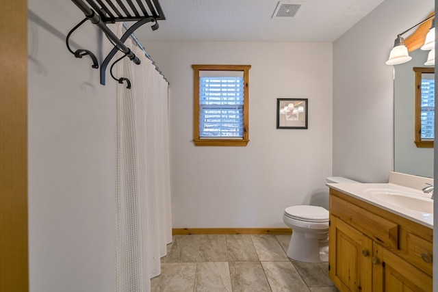 bathroom with vanity, a healthy amount of sunlight, and toilet