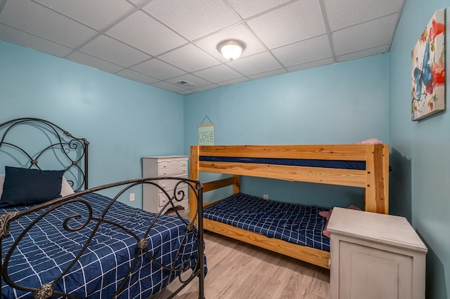 bedroom featuring a paneled ceiling and light hardwood / wood-style flooring