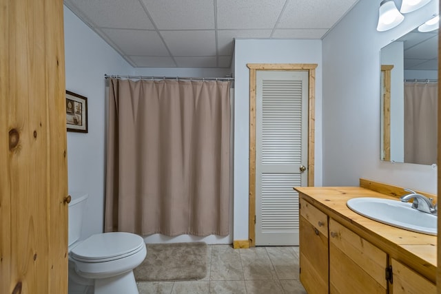 bathroom with vanity, a paneled ceiling, tile patterned floors, and toilet