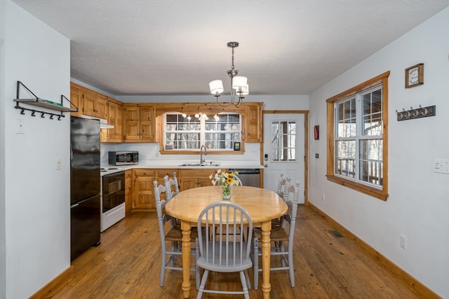 dining room with hardwood / wood-style flooring, sink, an inviting chandelier, and a textured ceiling