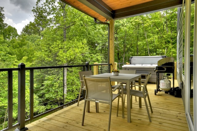 wooden deck with outdoor dining area and a forest view