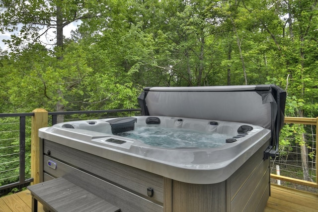 deck with a view of trees and a hot tub