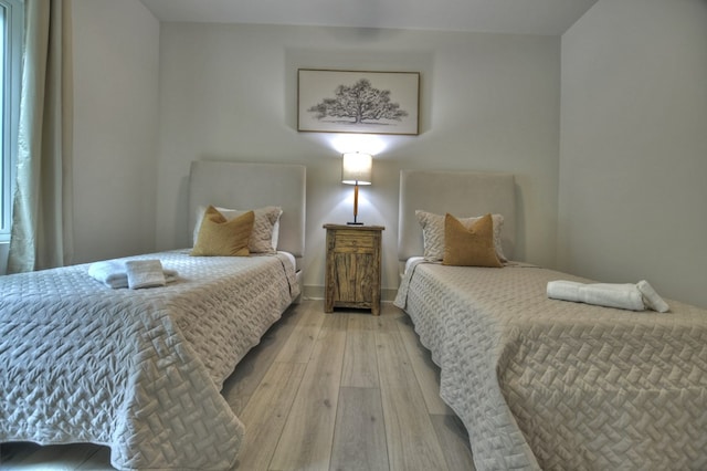 bedroom featuring light wood-style flooring and baseboards