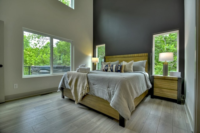 bedroom featuring multiple windows, visible vents, and light wood finished floors