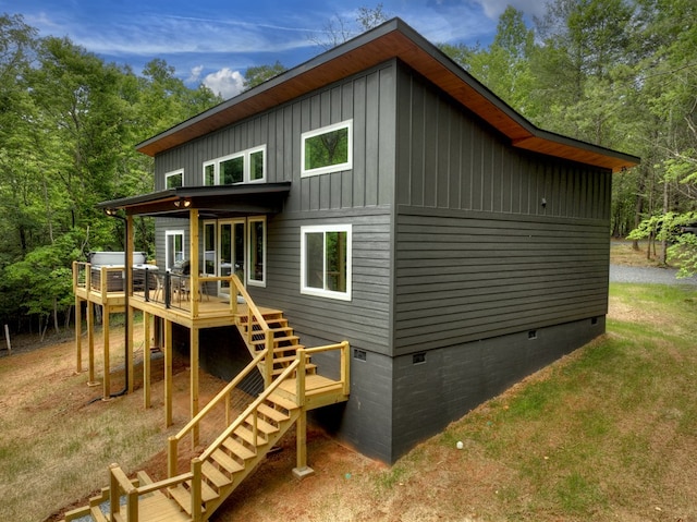 back of house with stairs, a deck, board and batten siding, and crawl space