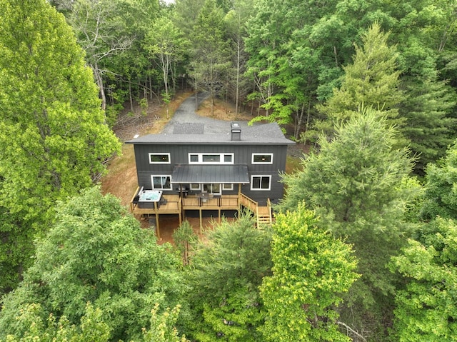 back of house with a forest view and a wooden deck