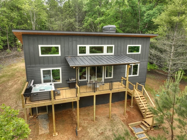 rear view of property with a standing seam roof, stairway, board and batten siding, and a wooden deck