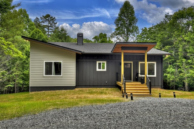 view of front of house featuring board and batten siding, roof with shingles, and a chimney