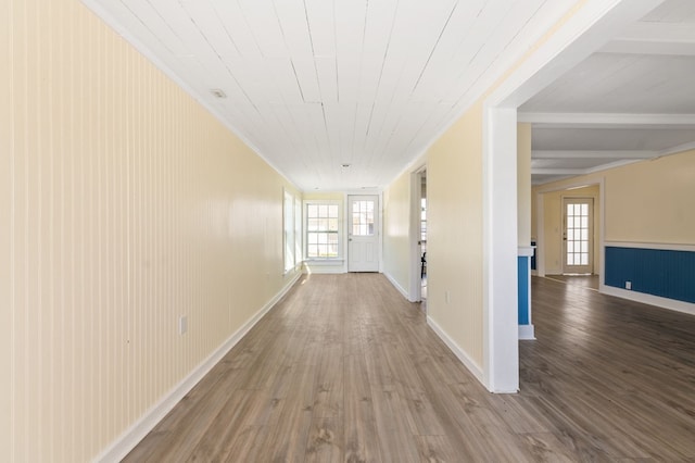 hall with wood walls, plenty of natural light, wooden ceiling, and hardwood / wood-style flooring