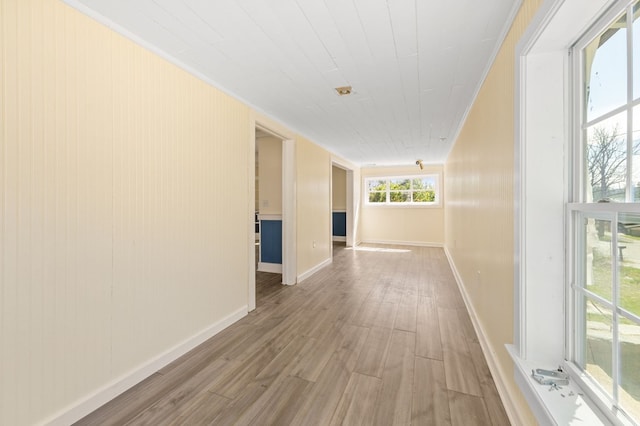 hall with light hardwood / wood-style floors and crown molding