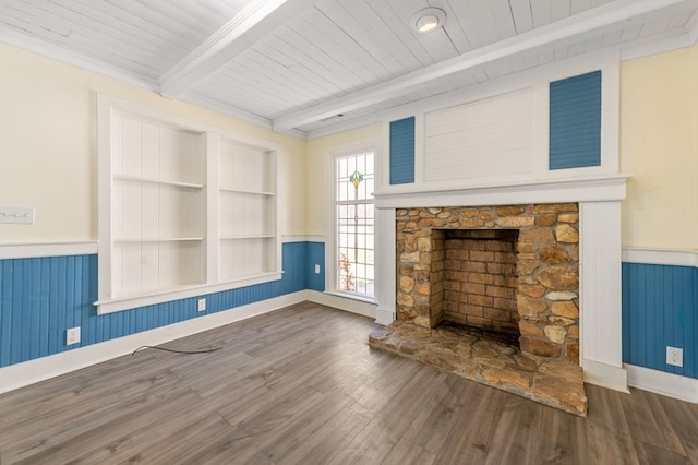 unfurnished living room with beam ceiling, wooden ceiling, dark wood-type flooring, a fireplace, and ornamental molding