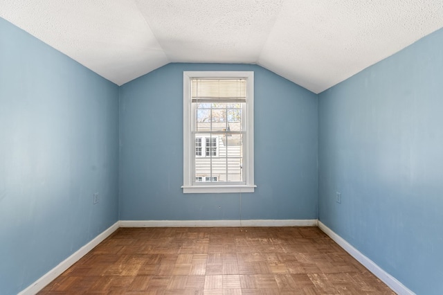 additional living space with a textured ceiling, parquet floors, and lofted ceiling